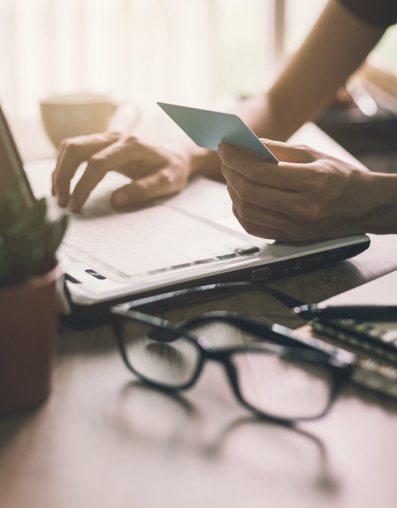 girl holding credit card and typing on laptop